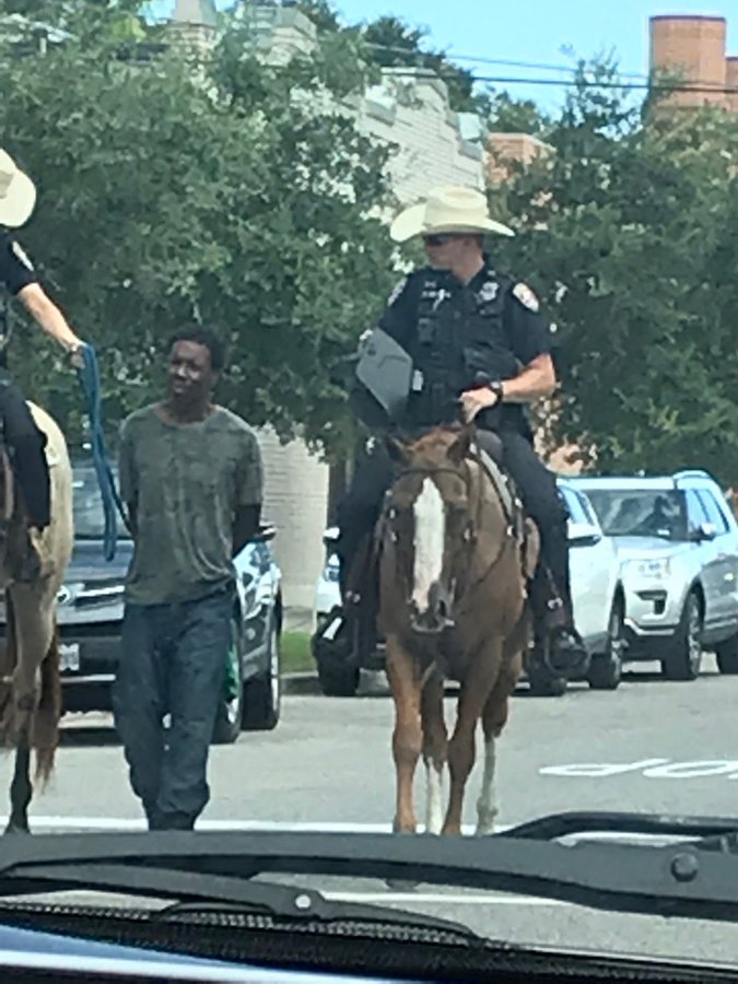 Donald Neely being led through Galveston streets by mounted officers.