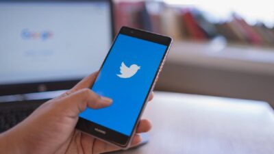 Twitter - hand witrh twitter logo on smartphone - Depositphotos