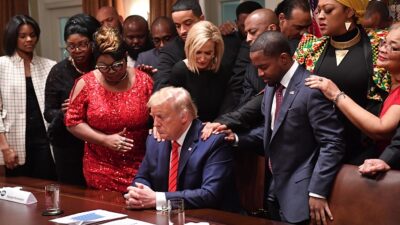 TOPSHOT - US President Donald Trump (C) stands in a prayer circle with African-American leaders in the Cabinet Room of the White House in Washington, DC, on February 27, 2020. (Photo by Nicholas Kamm / AFP) (Photo by NICHOLAS KAMM/AFP via Getty Images)