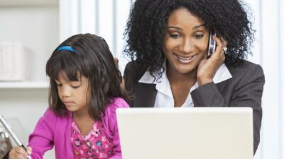 Woman working from home (with young daughter)Depositphotos