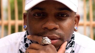 Jimmie Allen in a white baseball cap and bling