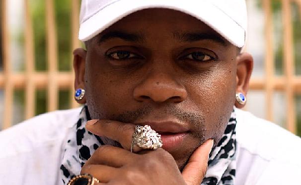 Jimmie Allen in a white baseball cap and bling