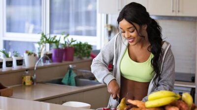 Woman in kitchen slicing fruit