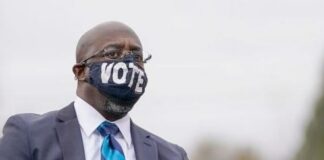 Warnock wearing VOTE mask