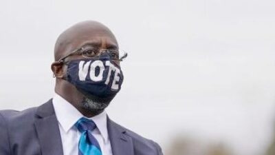 Warnock wearing VOTE mask