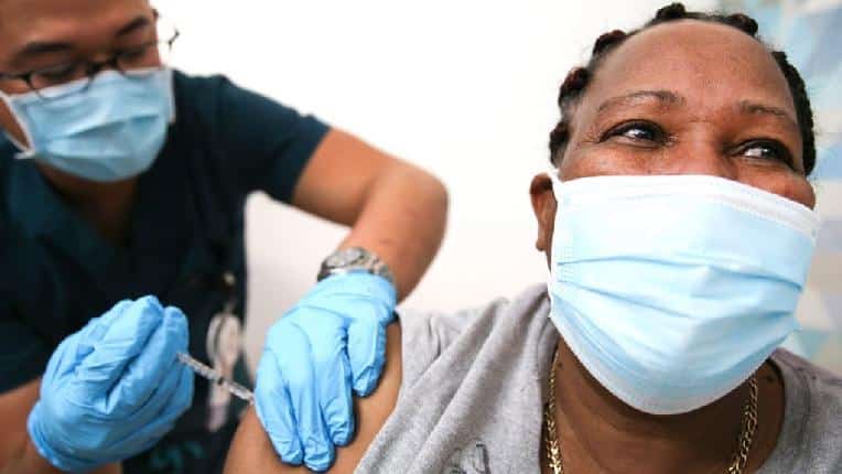 Black person (masked) getting vaccination / Getty
