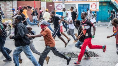 Protesters run during an opposition demonstration commemorating the Battle of Vertieres Day, the last major battle of the Second War of Haitian Independence, on 18 November 2019. Photo: Getty Images.