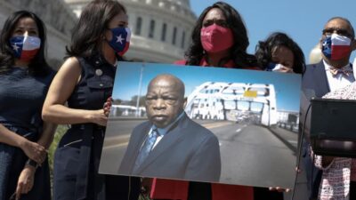 Rep. Terri A. Sewell (D-Ala.) holds a photo of the late congressman John Lewis (D-Ga.) at an event outside the Capitol on Aug. 24. (Anna Moneymaker/Getty Images)