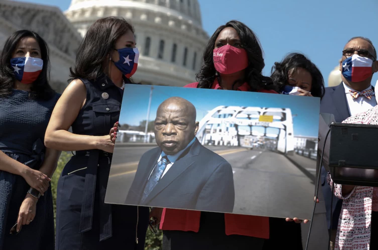Rep. Terri A. Sewell (D-Ala.) holds a photo of the late congressman John Lewis (D-Ga.) at an event outside the Capitol on Aug. 24. (Anna Moneymaker/Getty Images)
