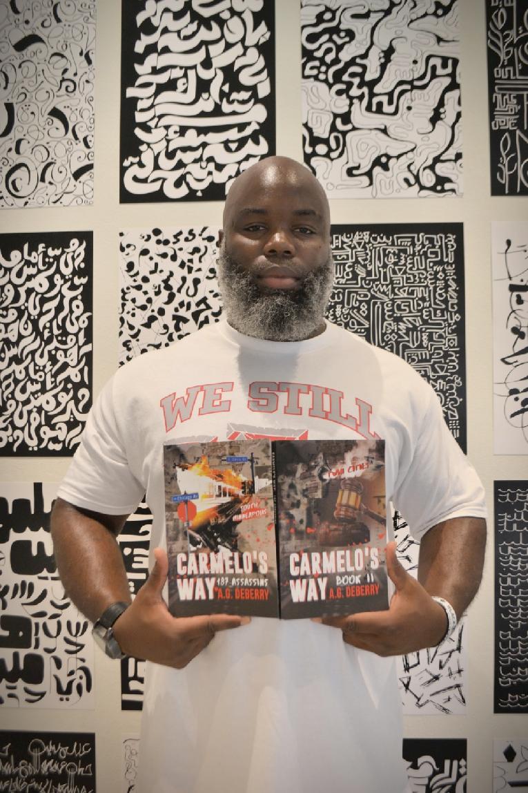 Armel Green (AG Deberry displaying both Carmelo's Way books)