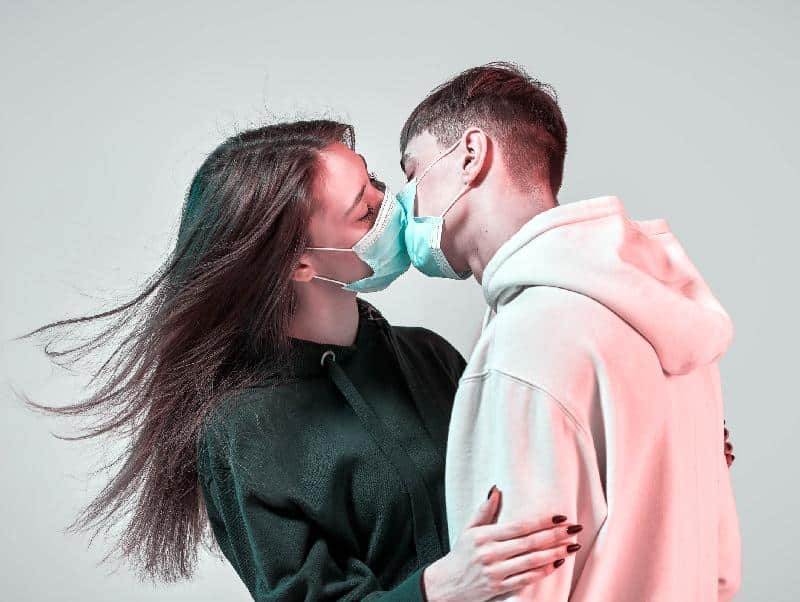Couple kissing with masks on (Getty)
