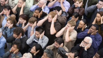 Crowd covering ears