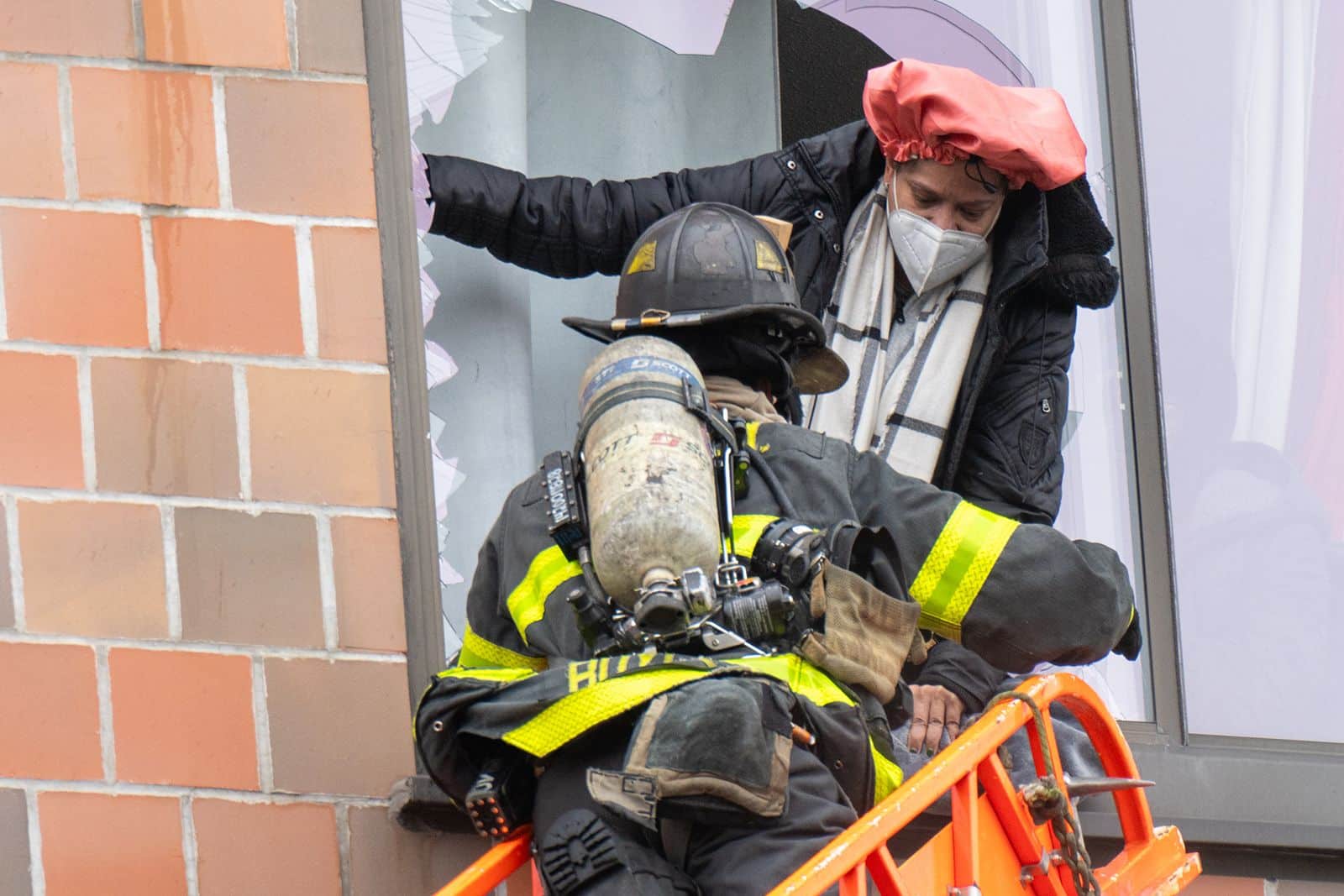 A firefighter helps a victim climb out a broken window to evacuate the building. Theodore Parisienne/New York Daily News/Getty Images