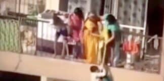 Woman dangles child over high rise balcony
