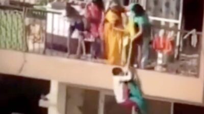 Woman dangles child over high rise balcony