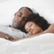 Black couple sleeping - GettyImages