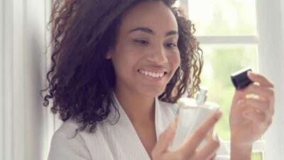 Black woman using perfume (iStock)