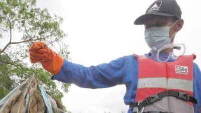 Man with used masks by river - Getty
