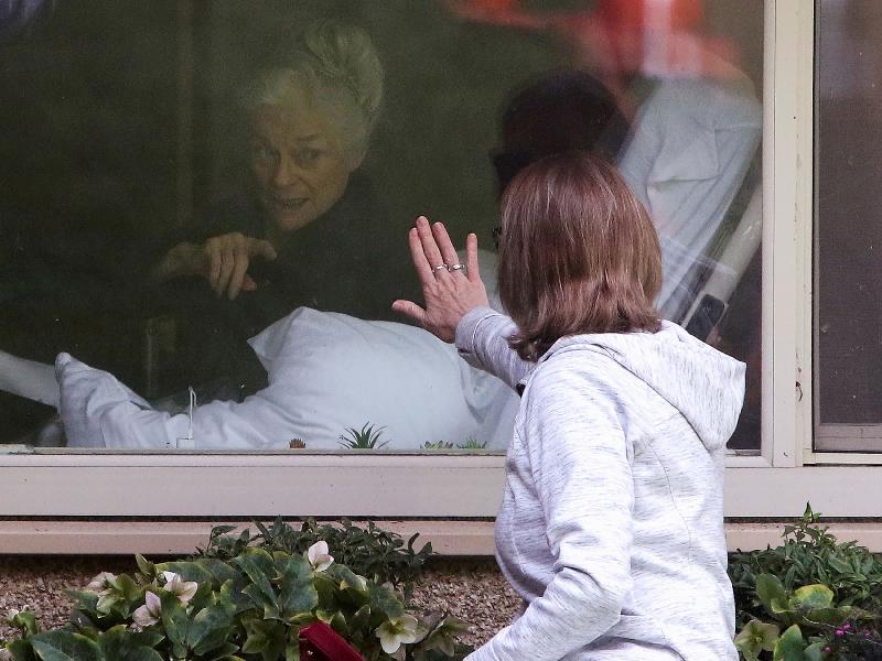 Woman Visiting COVID Patient Mother (Jason Redmond-Reuters)