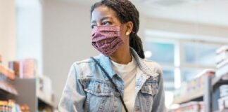 Black Woman wearing mask while shopping - 122933181_Gettyimages