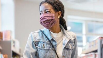 Black Woman wearing mask while shopping - 122933181_Gettyimages