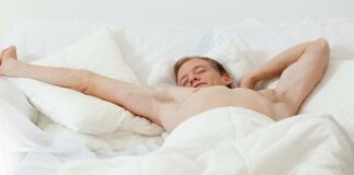 Single man in bed (white sheets) - iStock