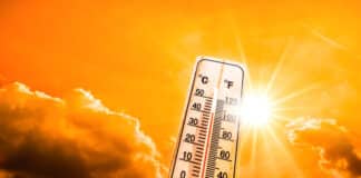 Weather Themometer - Hot summer or heat wave background, glowing sun on orange sky with thermometer