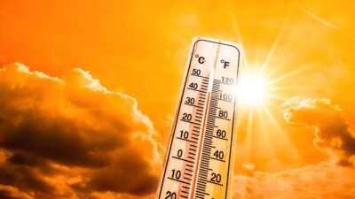 Weather Themometer - Hot summer or heat wave background, glowing sun on orange sky with thermometer