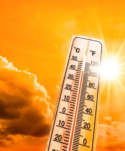Weather Themometer - Hot summer or heat wave background, glowing sun on orange sky with thermometer