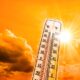 Weather Themometer - Hot summer or heat wave background, glowing sun on orange sky with thermometer