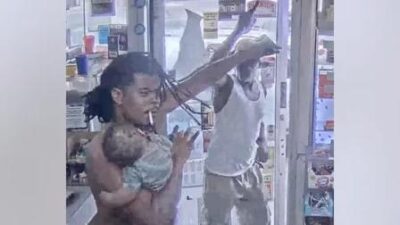 Man with baby and man with gun - screenshot