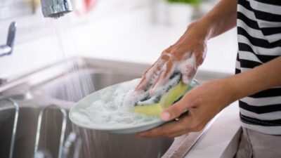 Washing Dishes with sponge (Adobe Stock)