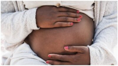 Close-up of a pregnant woman holding her belly - iStock