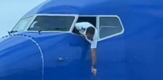 Southwest pilot hanging out of cockpit window to reteieve passenger's smartphone / via Southwest Airlines