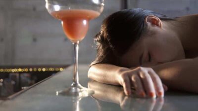 Woman drining too much (spiked drink) - iStock