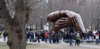The Embrace Sculpture and crowds (John Lamparski-NurPhoto via AP)