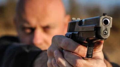 Cop with gun aimed - iStock