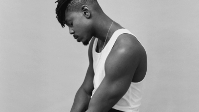 Ladipoe seated in white tank top