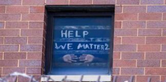 A sign on the window at the Cook County Jail complex reads, "Help, We Matter 2"