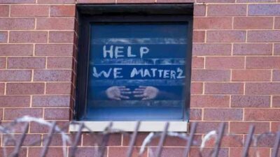 A sign on the window at the Cook County Jail complex reads, "Help, We Matter 2"