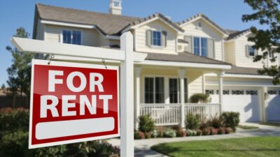 Right Facing Red For Rent Real Estate Sign in Front of Beautiful House. / Depositphotos.com