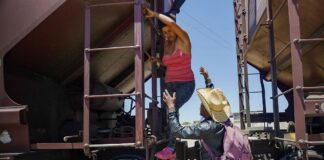 Relatives help a woman get off the train after she became too scared to climb down from the roof(Evelio Contreras-CNN)