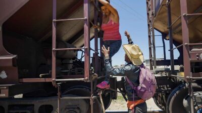 Relatives help a woman get off the train after she became too scared to climb down from the roof(Evelio Contreras-CNN)