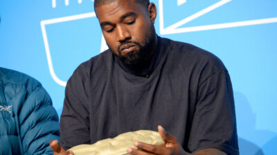 Kanye West holds a Yeezy shoe