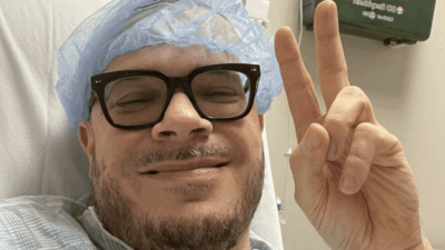 Shaun King holds up peace sign in hospital bed