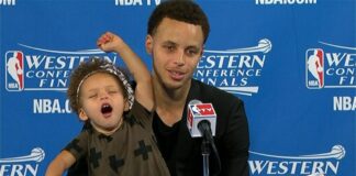 Riley Curry stretches her arms while joining father Stephen Curry at his post-game press conference