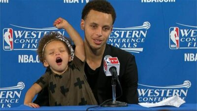 Riley Curry stretches her arms while joining father Stephen Curry at his post-game press conference