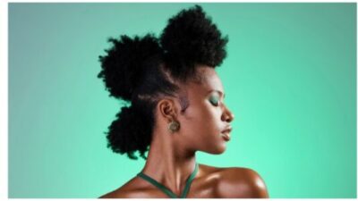 Black woman, makeup and face on skin for beauty, fashion and cosmetics against green backdrop. Model, girl and hair, show afro, skincare and health in portrait with studio background in New Orleans