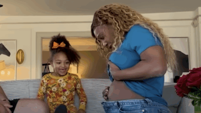 Serena Williams shows off her baby bump to daughter Olympia on their sofa