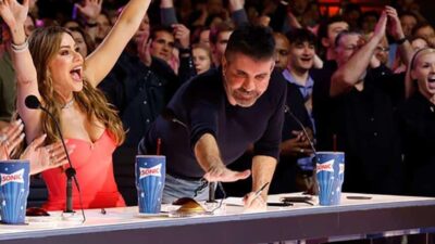 Simon Cowell reaching for the golden buzzer (Trae Patton - NBC)
